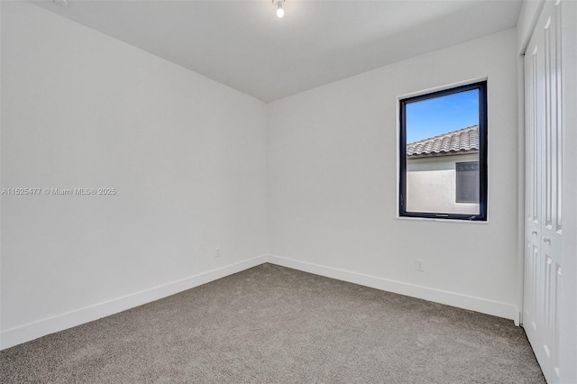 empty room featuring carpet flooring and baseboards