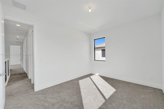 spare room with recessed lighting, carpet floors, visible vents, and baseboards