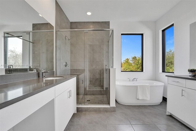 bathroom with plus walk in shower, tile floors, and oversized vanity