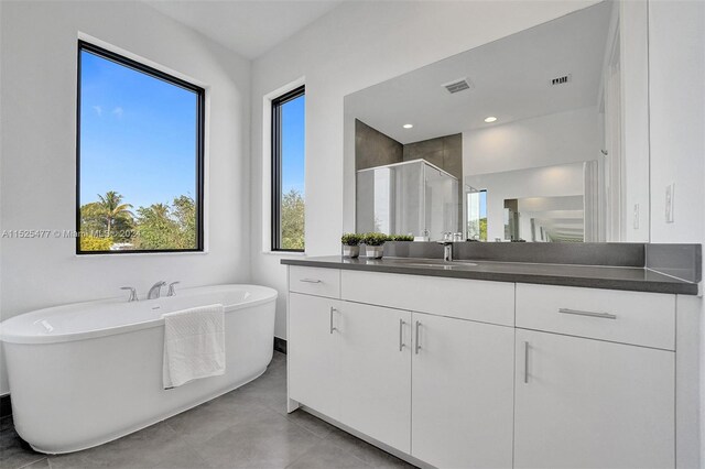 bathroom featuring tile floors, vanity, and plus walk in shower