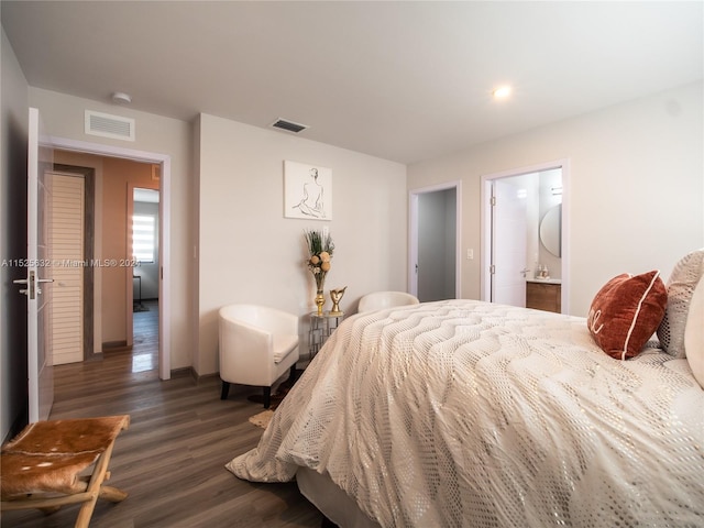 bedroom featuring ensuite bath and dark hardwood / wood-style flooring