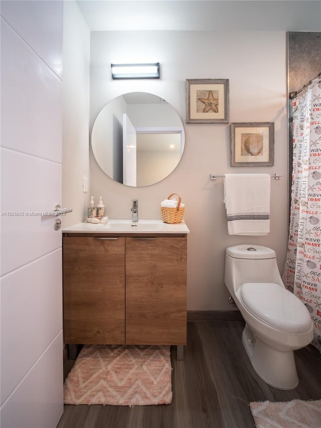 bathroom featuring toilet, vanity, and hardwood / wood-style flooring