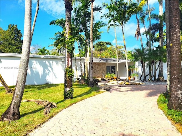 ranch-style home featuring a front lawn