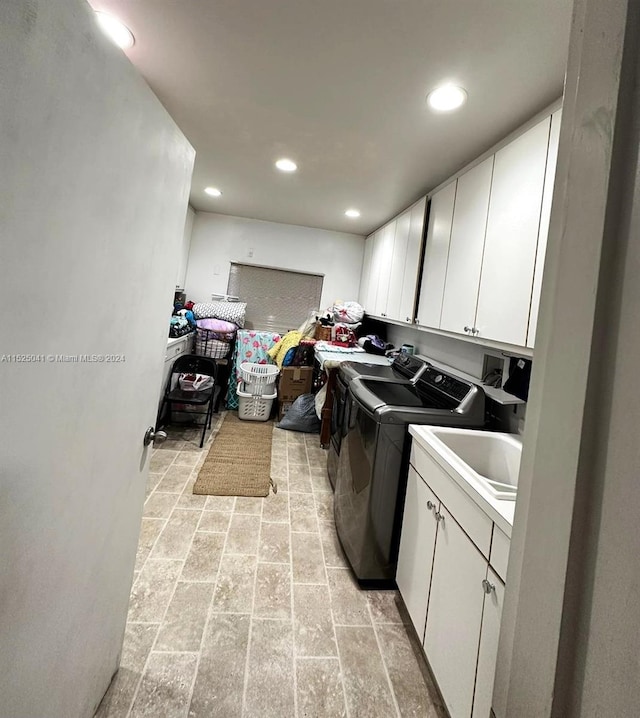 laundry room featuring cabinets, washer and dryer, and light tile flooring