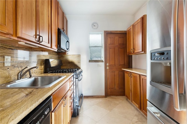 kitchen with tasteful backsplash, sink, light tile patterned flooring, and black appliances