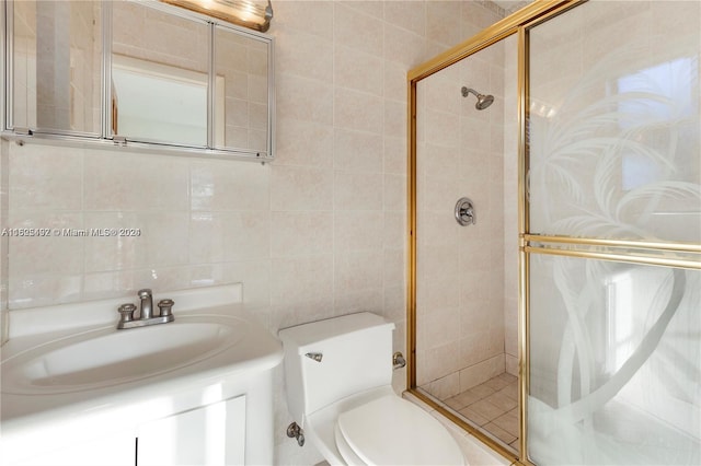 bathroom featuring tile walls, vanity, an enclosed shower, and toilet