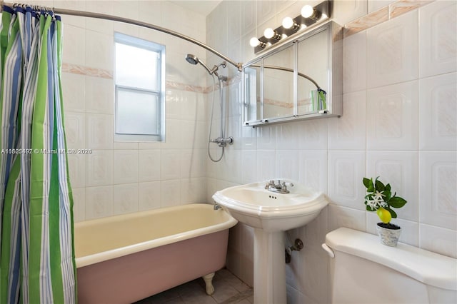 bathroom with tile patterned flooring, shower / bath combo, toilet, and tile walls