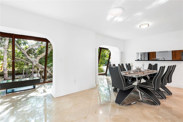 dining space with light tile floors and a wealth of natural light