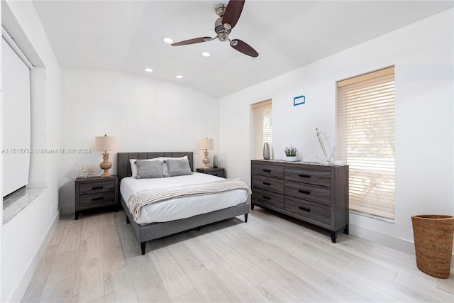 bedroom with ceiling fan, vaulted ceiling, and light wood-type flooring