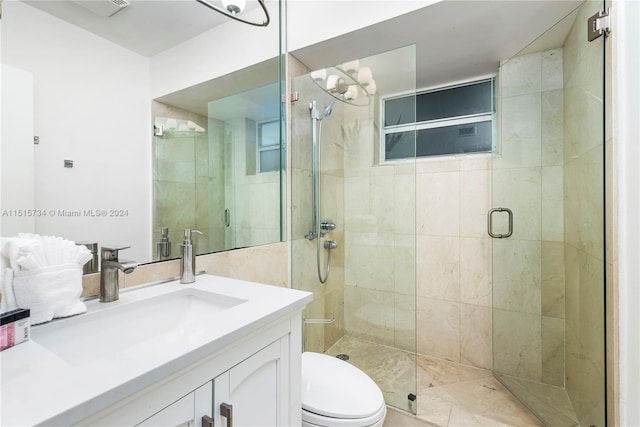 bathroom with vanity, a shower with shower door, and toilet