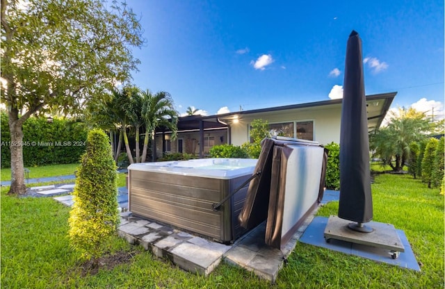 wooden deck with a lawn and a hot tub