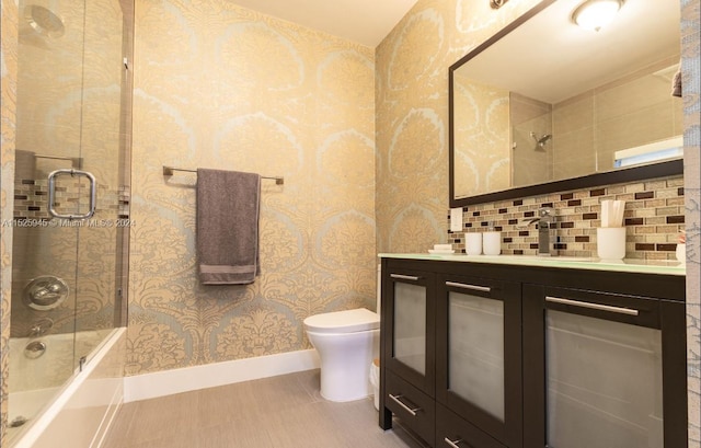 full bathroom with toilet, vanity, backsplash, combined bath / shower with glass door, and tile flooring