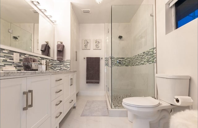 bathroom with vanity, backsplash, tile floors, toilet, and a shower with shower door