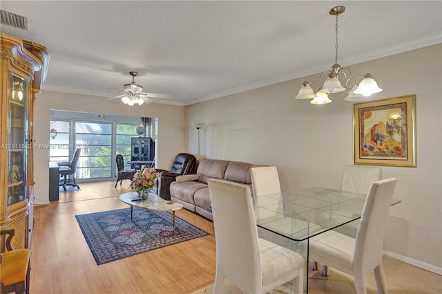 dining area featuring ornamental molding, light hardwood / wood-style floors, and ceiling fan with notable chandelier