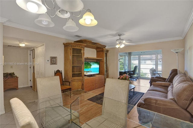 tiled dining room featuring ornamental molding and ceiling fan with notable chandelier