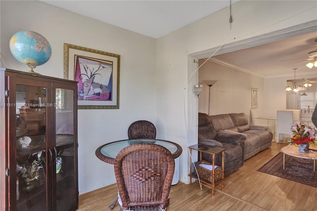 living room featuring ceiling fan with notable chandelier and light wood-type flooring