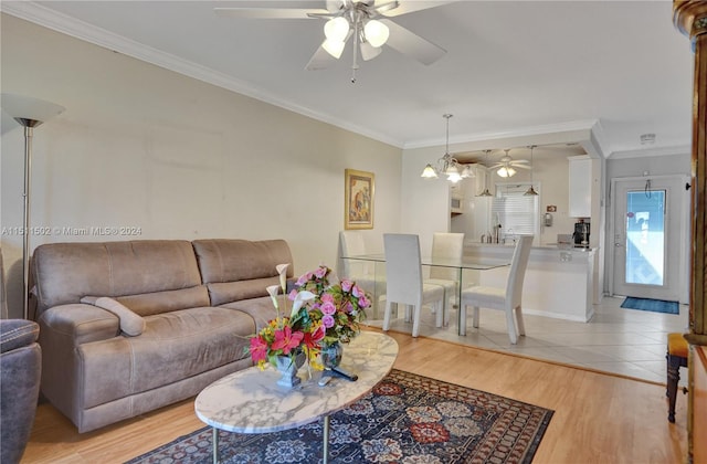 tiled living room featuring ceiling fan with notable chandelier and ornamental molding