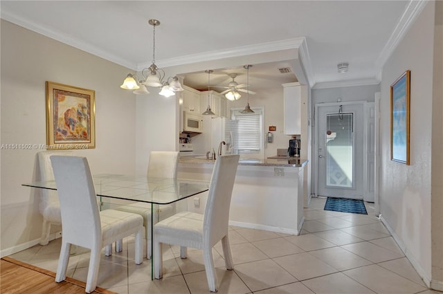 dining room featuring ceiling fan with notable chandelier, ornamental molding, and light tile flooring