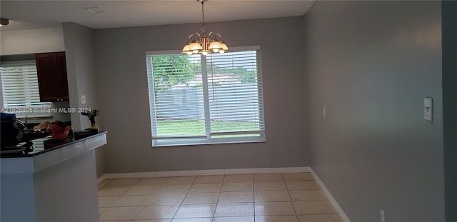 unfurnished dining area with a chandelier and light tile patterned floors