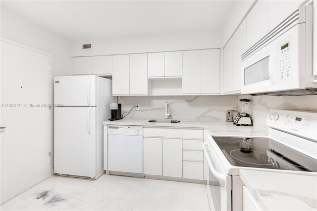 kitchen with white appliances, light stone counters, light tile floors, sink, and white cabinets