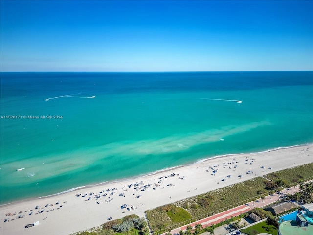 drone / aerial view featuring a beach view and a water view