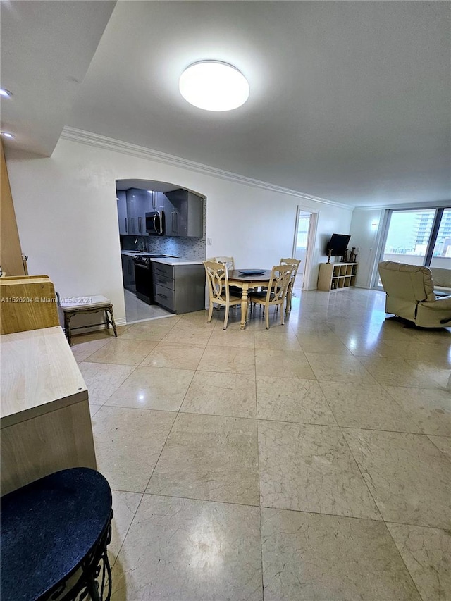 dining area with light tile floors and ornamental molding