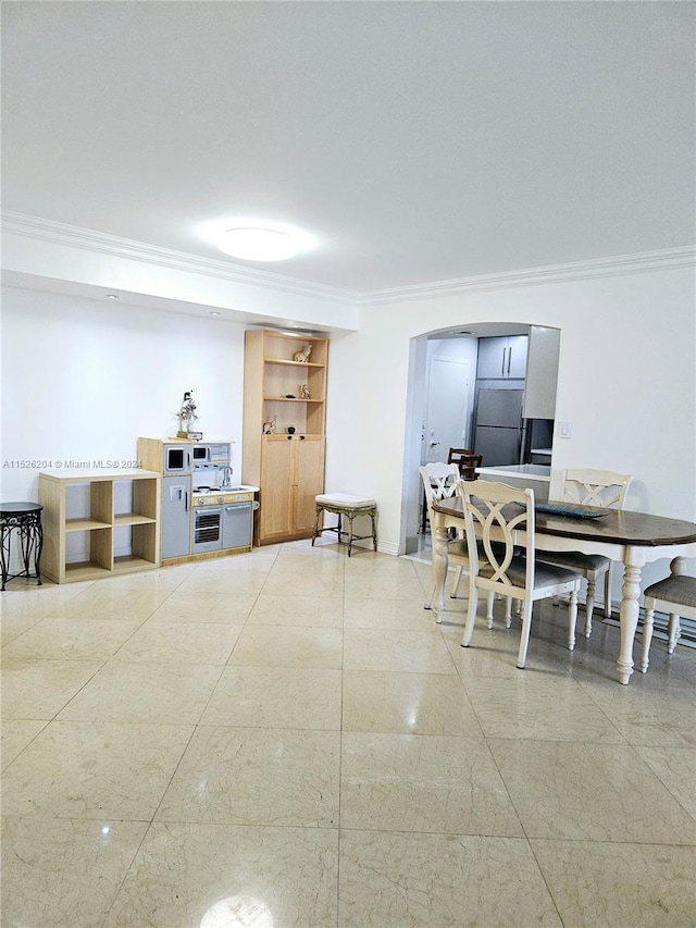 dining space featuring light tile floors and crown molding