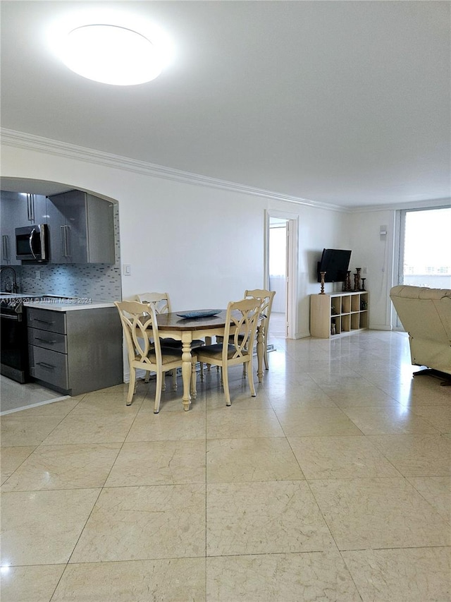 tiled dining space featuring crown molding