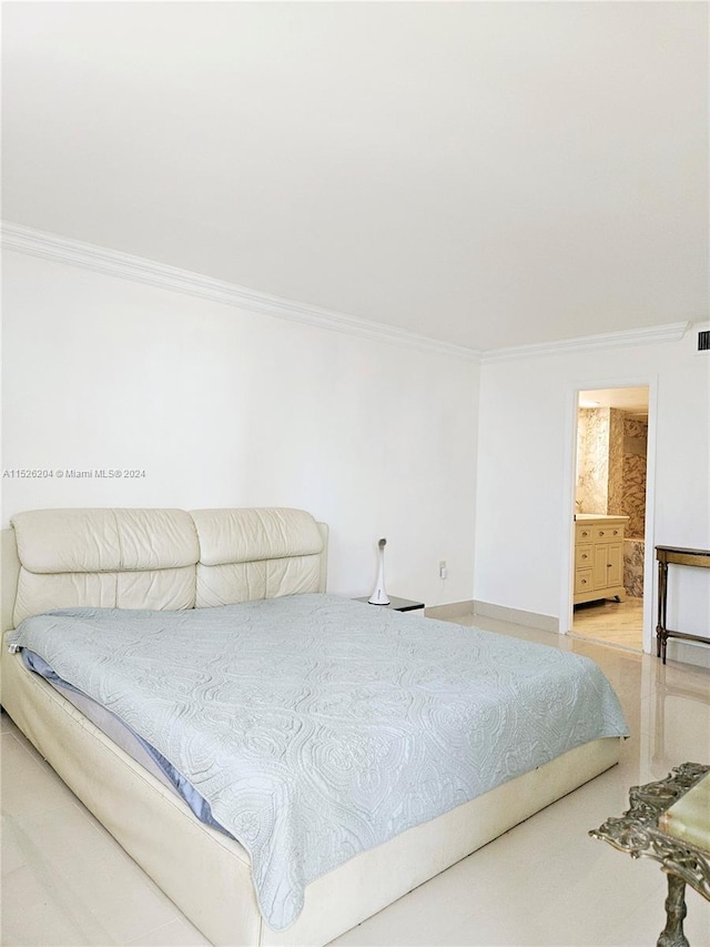 bedroom with light hardwood / wood-style floors, ensuite bathroom, and ornamental molding