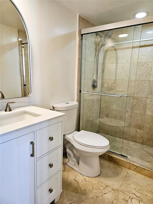 bathroom with an enclosed shower, toilet, tile floors, and vanity with extensive cabinet space