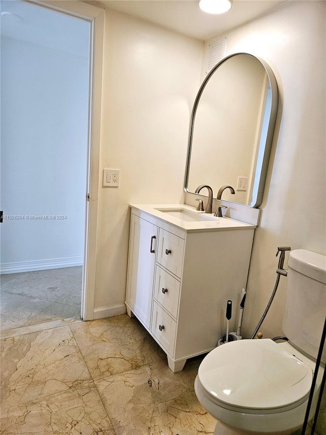 bathroom featuring oversized vanity, toilet, and tile floors