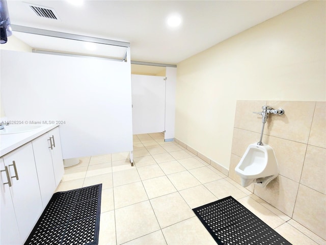 bathroom with a bidet, vanity, and tile floors