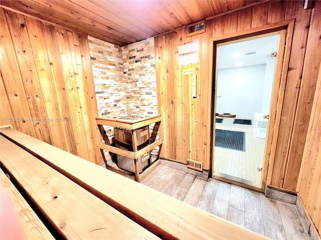 view of sauna / steam room featuring wooden walls and tile floors