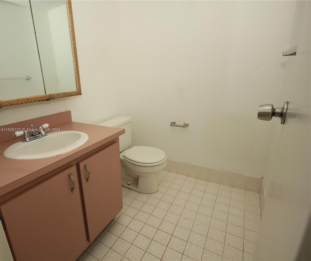 bathroom featuring toilet, tile flooring, and vanity