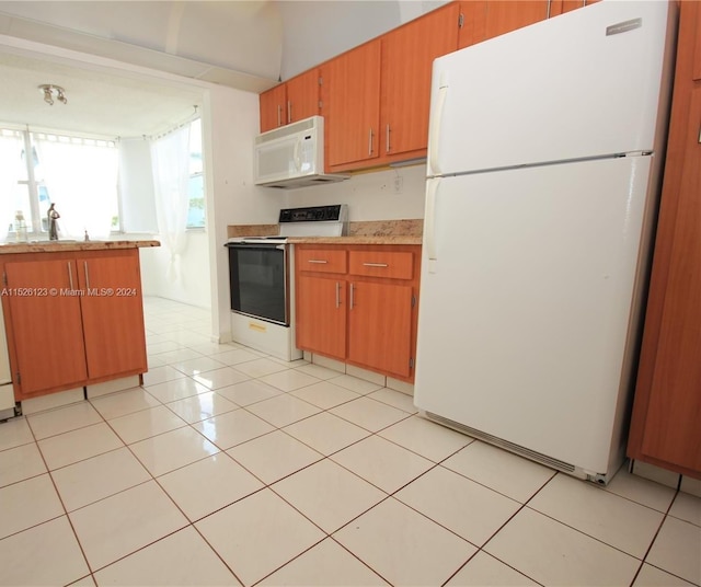 kitchen featuring white appliances, light tile flooring, and sink