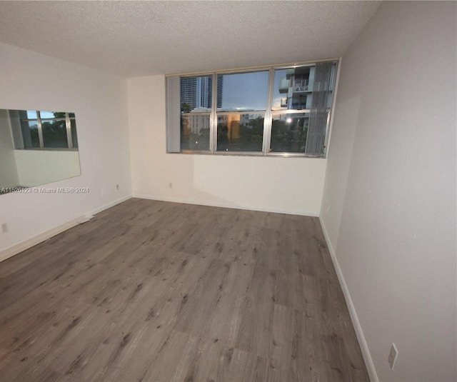 spare room featuring hardwood / wood-style floors and a textured ceiling