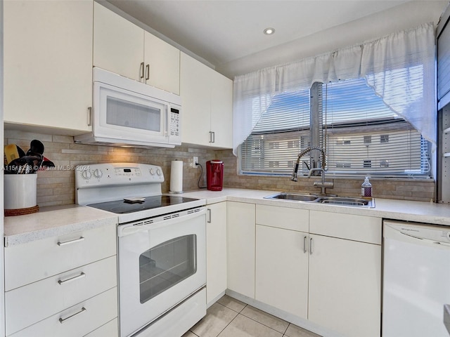 kitchen with white appliances, sink, light tile floors, white cabinets, and tasteful backsplash