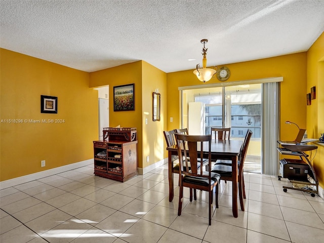 dining space featuring a textured ceiling and light tile flooring