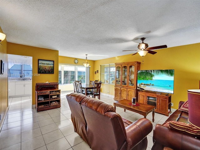 living room featuring a textured ceiling, ceiling fan, and light tile flooring