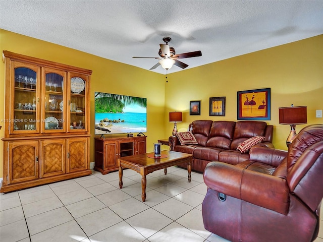 living room with a textured ceiling, ceiling fan, and light tile floors