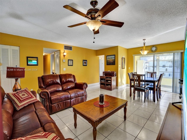 living room with light tile floors, a textured ceiling, and ceiling fan