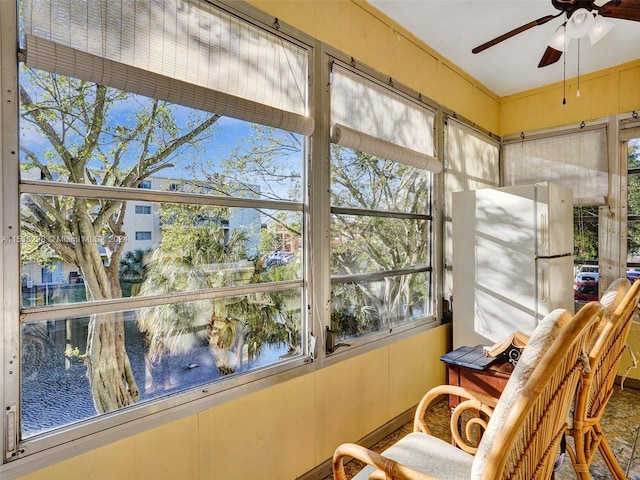 unfurnished sunroom with ceiling fan