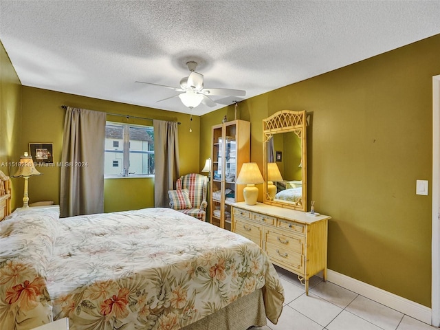 tiled bedroom featuring ceiling fan and a textured ceiling