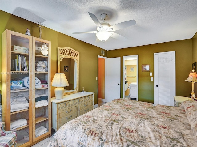 bedroom featuring light tile floors, ceiling fan, and a textured ceiling