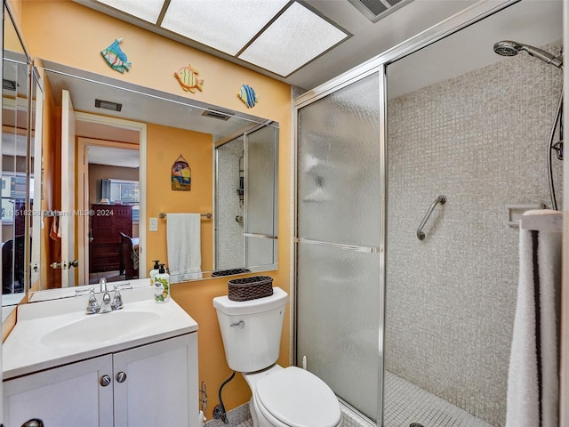 bathroom featuring vanity, a shower with shower door, and toilet