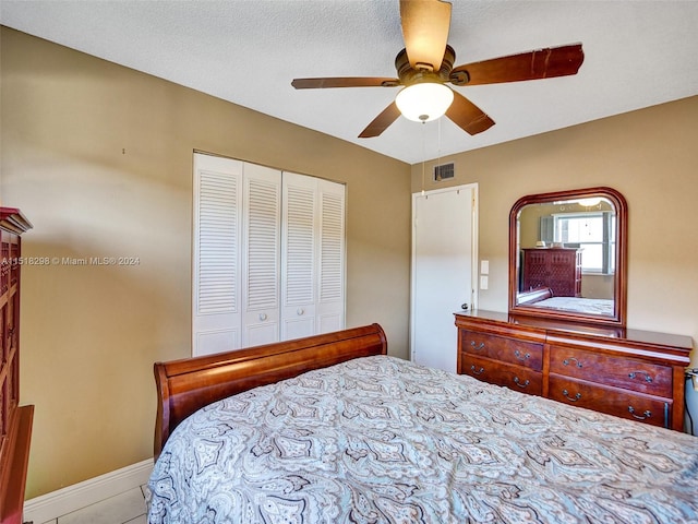 bedroom featuring a closet, ceiling fan, and a textured ceiling