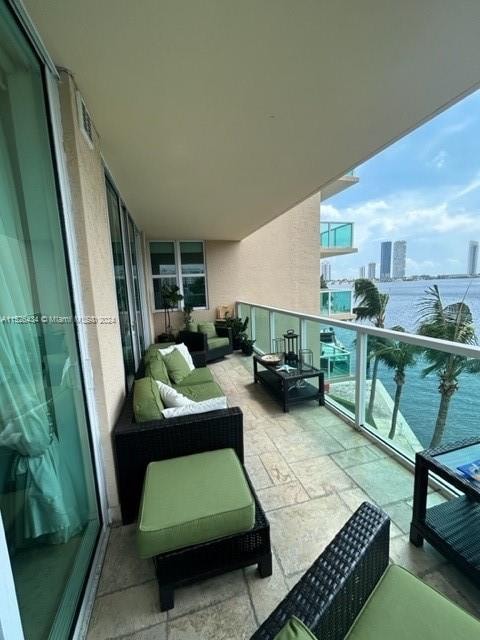 balcony featuring a water view and outdoor lounge area