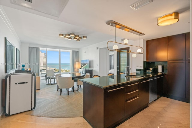 kitchen with decorative light fixtures, sink, a breakfast bar area, and paneled built in refrigerator