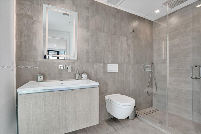 bathroom featuring a shower with door, tile walls, toilet, and tile patterned flooring