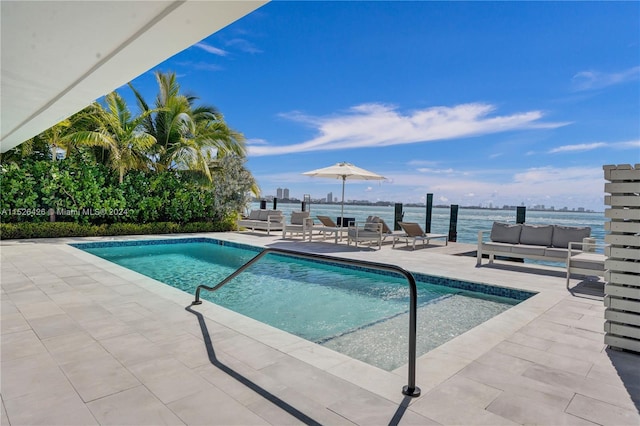 view of swimming pool with a patio and a water view